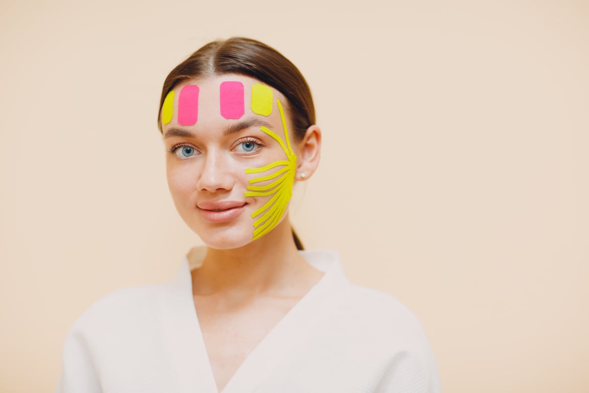 Beautiful Woman Applying Tape Lifting Treatment on Face